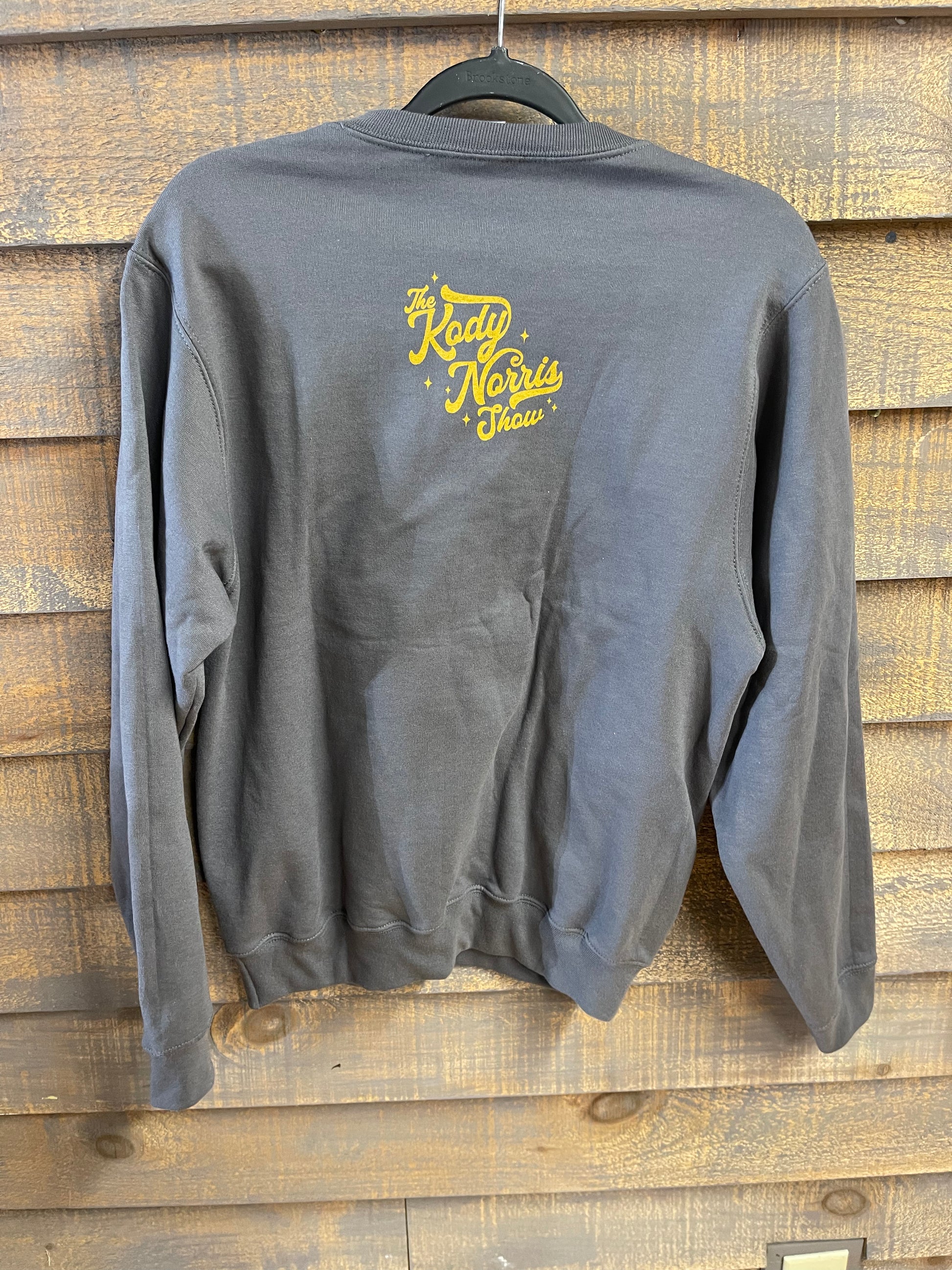 The Kody Norris Show Graphic Sweatshirt Available only in Charcoal with Gold Lettering. Port & Co. Brand. Super Soft! Includes small logo on back collar.