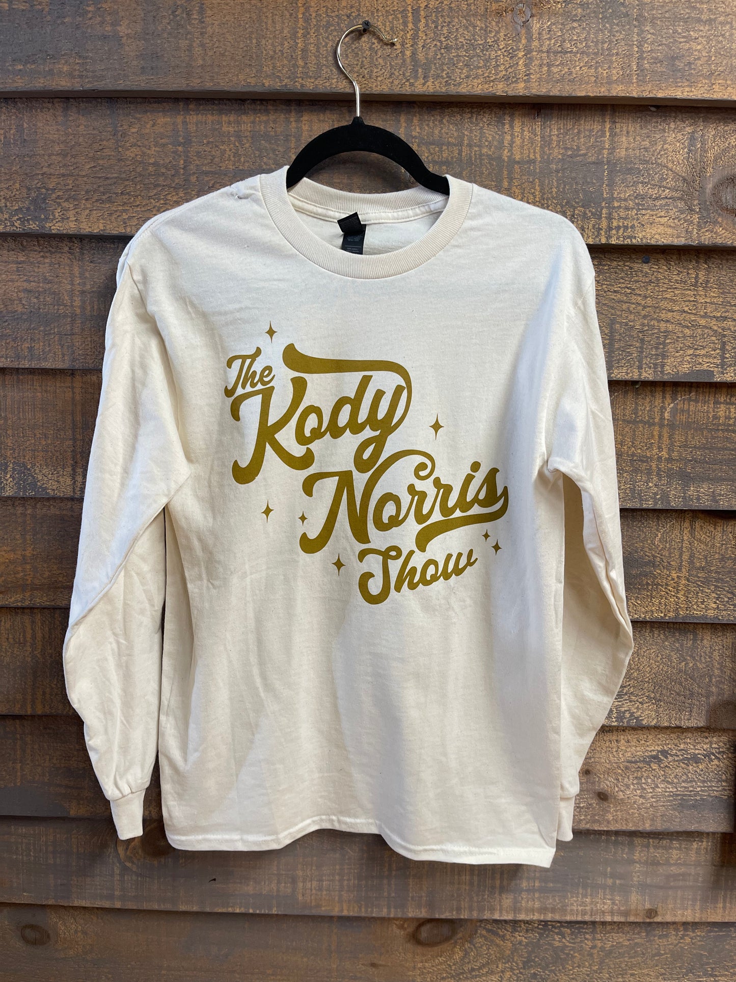 The Kody Norris Show Graphic Tee (Long Sleeve, Color Natural) Natural with Gold Lettering on the front and back Long Sleeve Gildan.